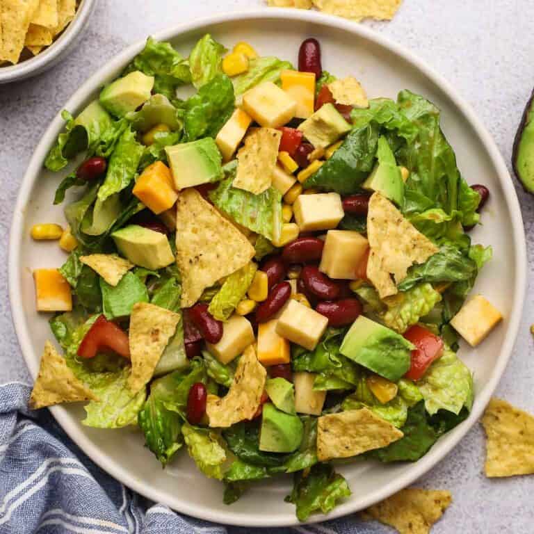 Overhead view of a plate of santa fe chopped salad topped with tortilla chips.