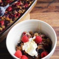 Raspberry dark chocolate baked oatmeal in a bowl with yogurt and fresh raspberries