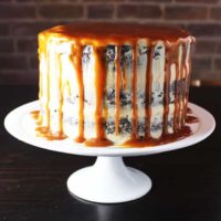 Caramel chocolate cake on a plate with coconut caramel frosting and caramel drizzle