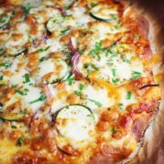 Veggie pizza, unsliced, on parchment paper
