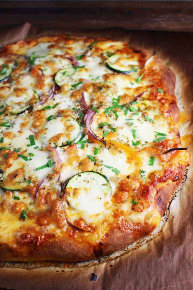 Veggie pizza, unsliced, on parchment paper