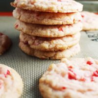 A stack of cherry almond sugar cookies on a baking mat