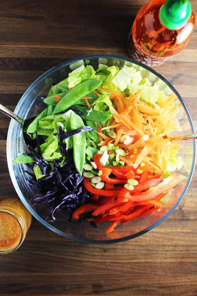 Chopped veggies for Asian chicken salad in a bowl, arranged in a rainbow