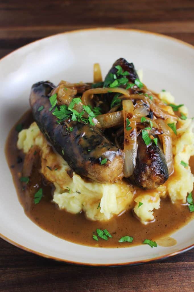 Bangers and mash recipe with gravy in a shallow bowl