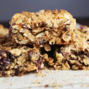 Chewy granola bars stacked on a sheet of parchment paper