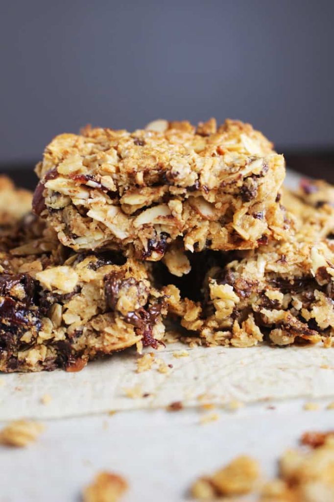 Chewy granola bars stacked on a sheet of parchment paper