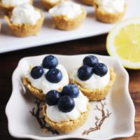 Lemon cheesecake tarts garnished with blueberries on a plate