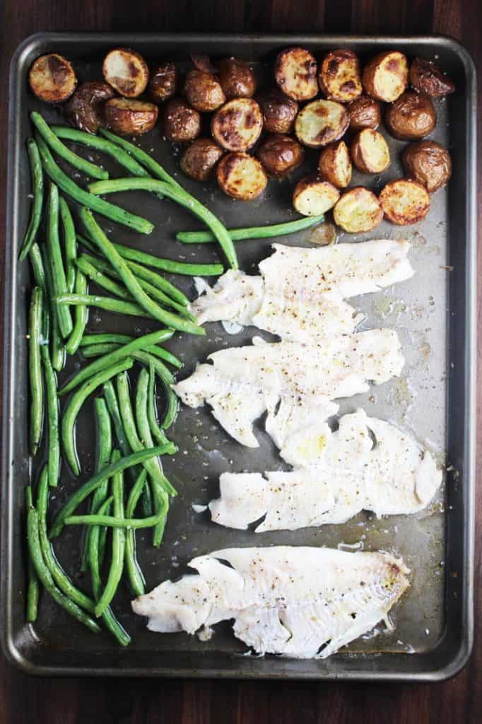 White fish, green beans and potatoes on a sheet pan for sheet pan dinner
