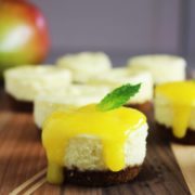 Mini cheesecakes with mango and biscoff crust on a wooden board