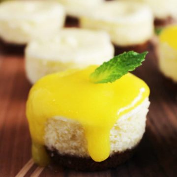 Mini cheesecake topped with mango coulis and a mint leaf