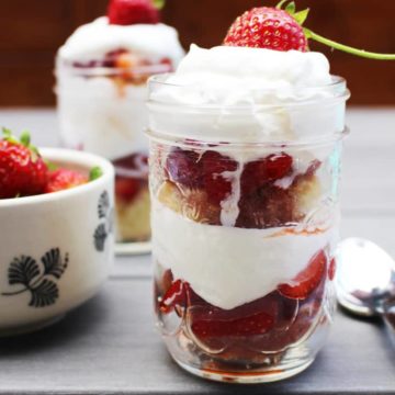 Easy strawberry shortcakes in pint-size mason jars on a table outdoors