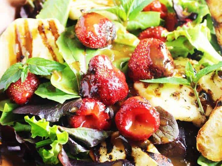 Grilled halloumi and strawberry salad in a wooden bowl