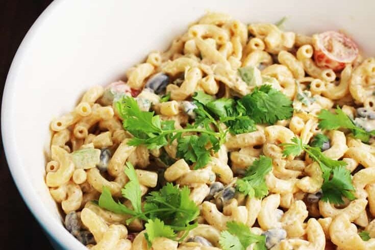 Large bowl of creamy taco macaroni salad sprinkled with cilantro