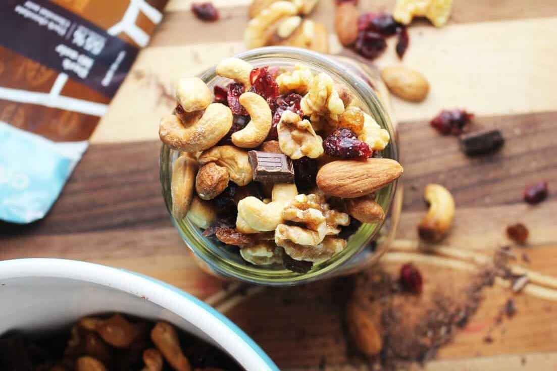 Healthy trail mix in a jar on a wooden board