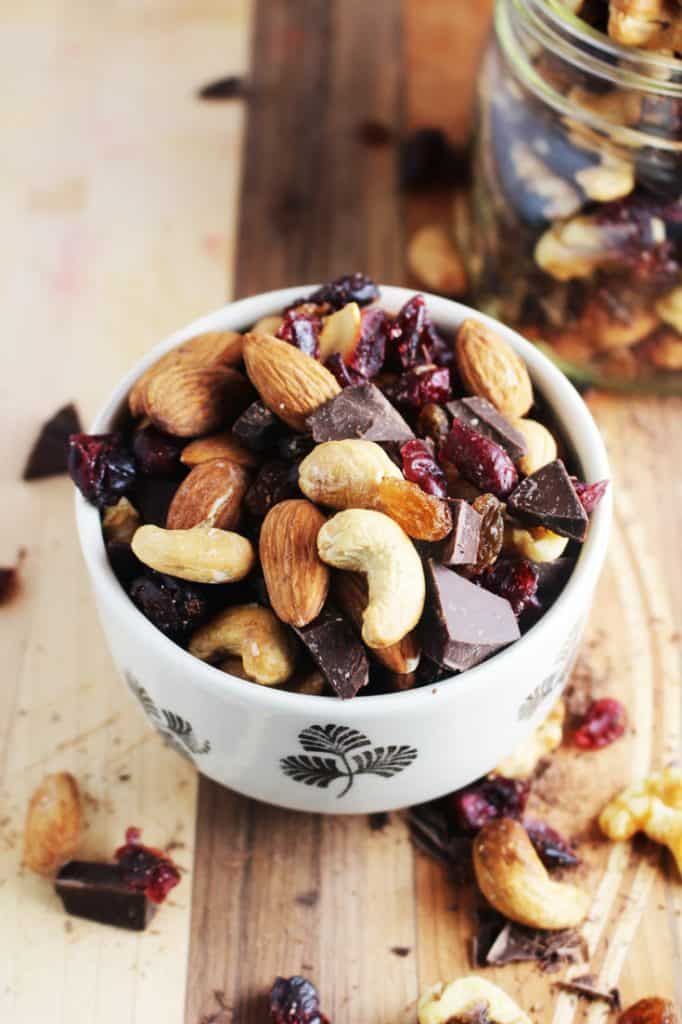 Healthy trail mix in a bowl on a wooden board