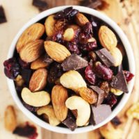 healthy trail mix in a bowl on a wooden cutting board