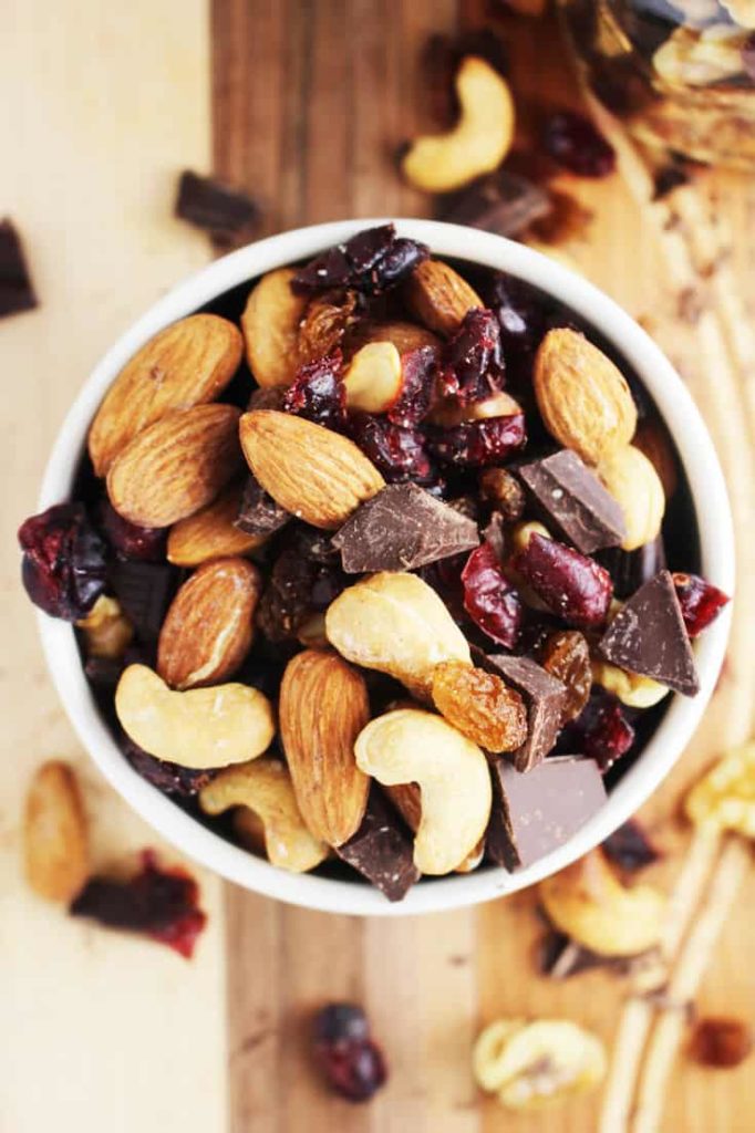 healthy trail mix in a bowl on a wooden cutting board 