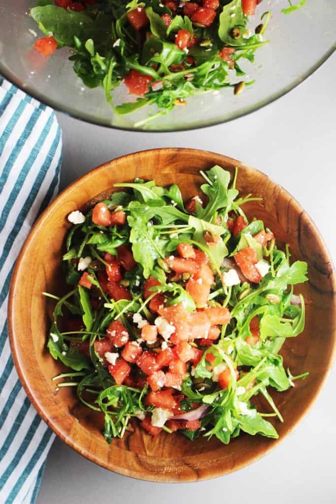 Mexican watermelon salad with arugula in a wooden bowl