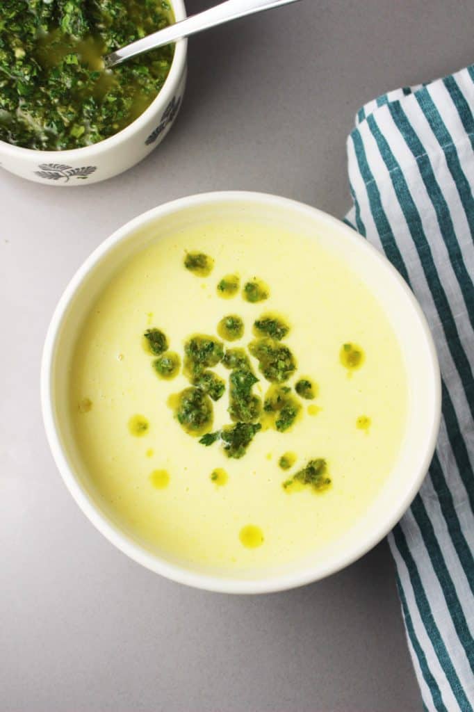 Fresh creamy corn soup recipe in a bowl with chimichurri on the side