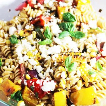 Summer pasta salad with grilled vegetables in a glass salad bowl