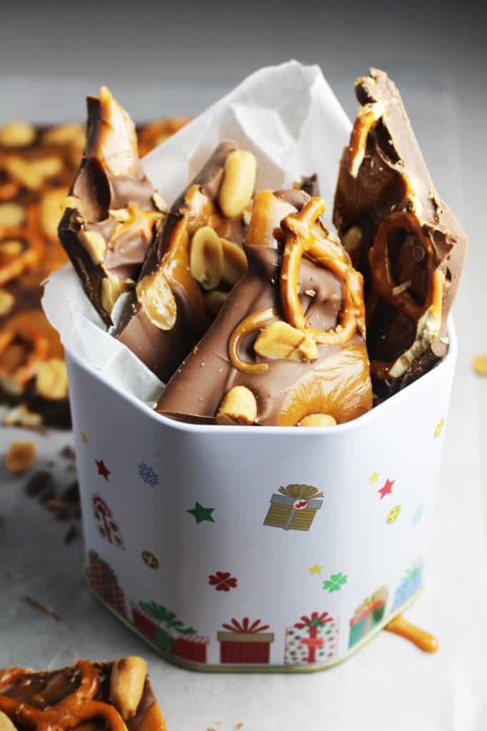 chocolate bark peices in a Christmas tin with wax paper