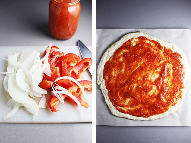 sliced red bell peppers and onions on a cutting board, and pizza dough slathered with pizza sauce