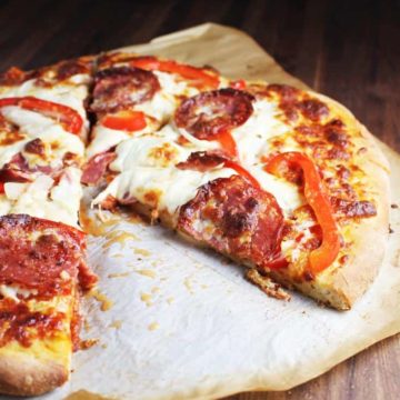 Sliced pepperoni pizza on a piece of parchment paper