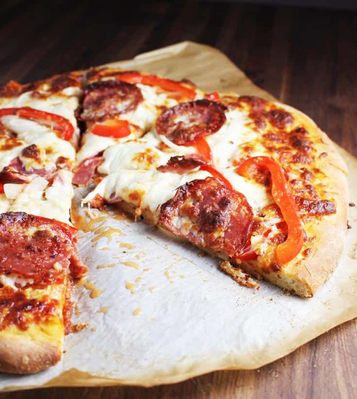 Sliced pepperoni pizza on a piece of parchment paper