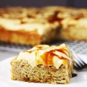 a piece of banana caramel cake with caramel frosting on a white plate
