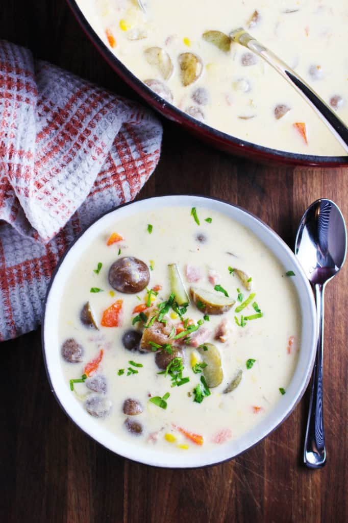 A bowl of potato chowder with corn and ham
