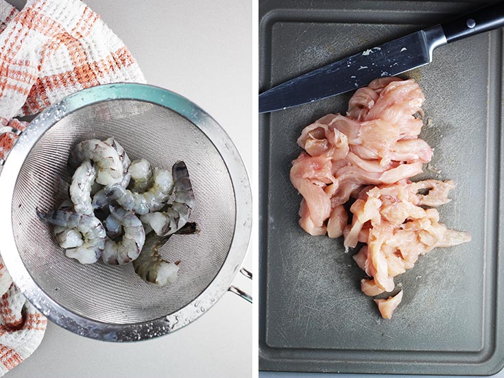 Raw shrimp in a colander and raw chicken sliced on a cutting board
