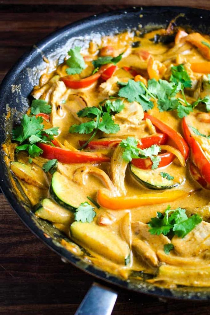 Thai red curry with chicken, rep pepper and zucchini in a pan