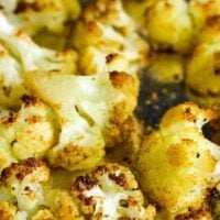 Roasted cauliflower florets on a foil-lined baking sheet