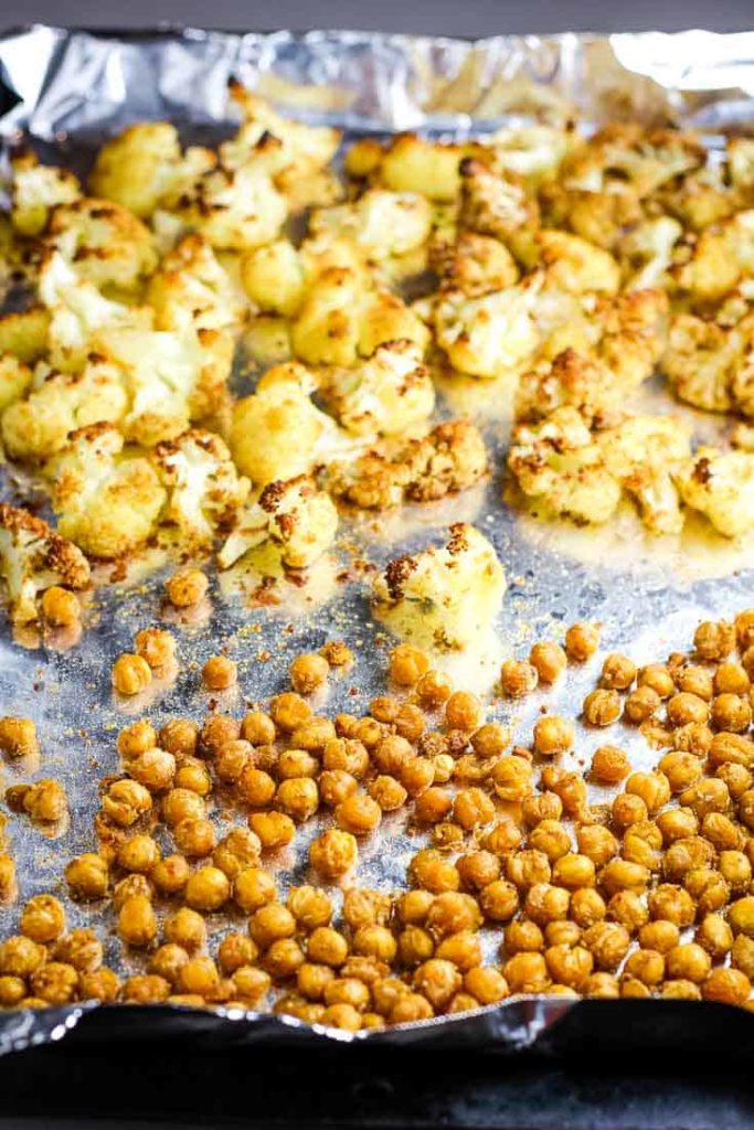 Roasted cauliflower and chickpeas on a foil-lined baking sheet