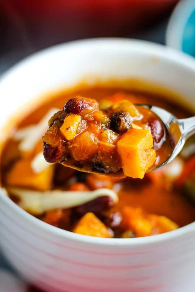 A spoonful of vegetarian sweet potato chili over a bowlful.