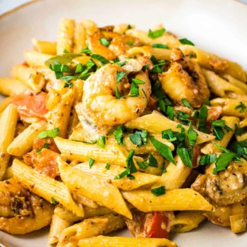 A bowl of Cajun shrimp pasta in a creamy sauce sprinkled with parsley