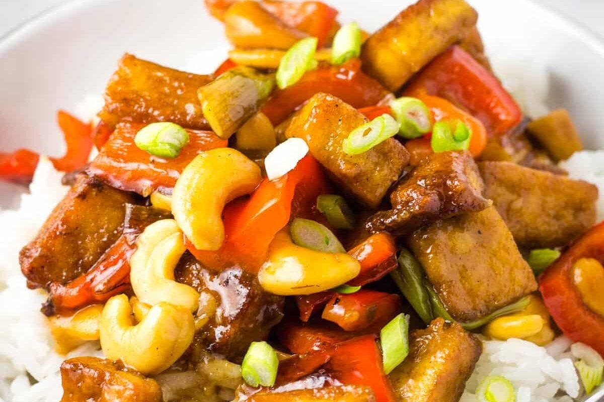 A bowl of tofu stir fried with cashews over white rice