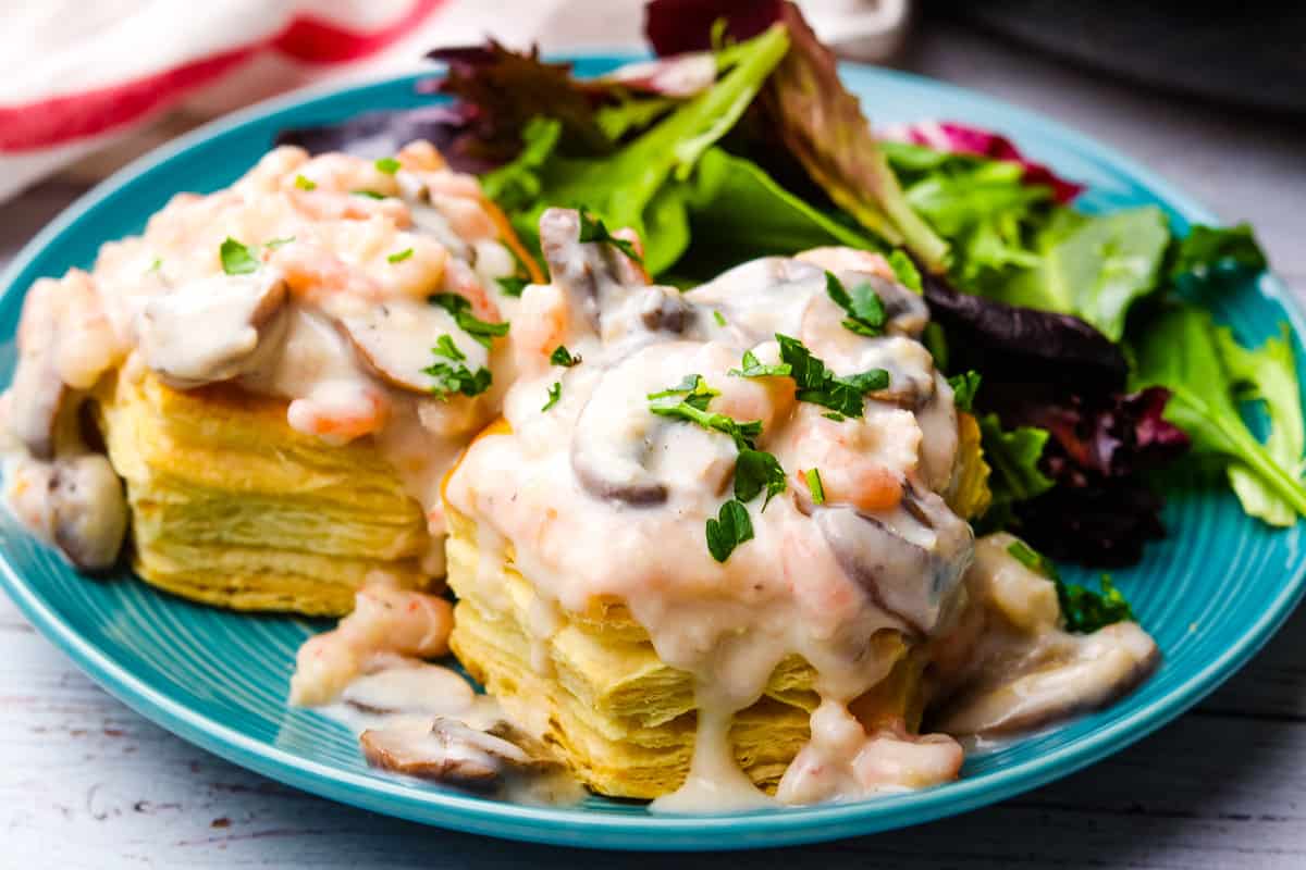 Shrimp and mushroom vol-au-vents on a blue plate with salad