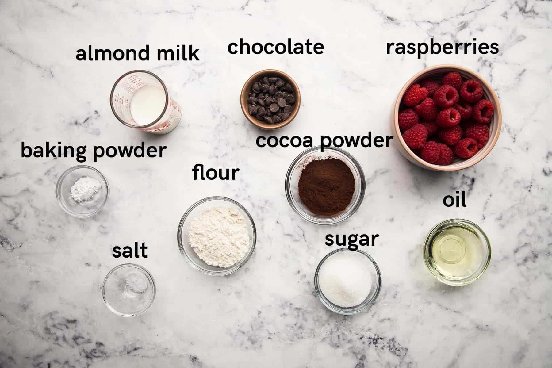 Picture of almond milk, chocolate, raspberries, baking powder, flour, salt, sugar, and oil.