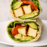 Two halves of a vegan tofu wrapped stacked on top of each other.