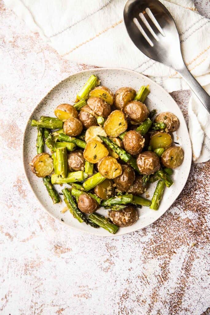 Roasted asparagus and potatoes served in a dish.
