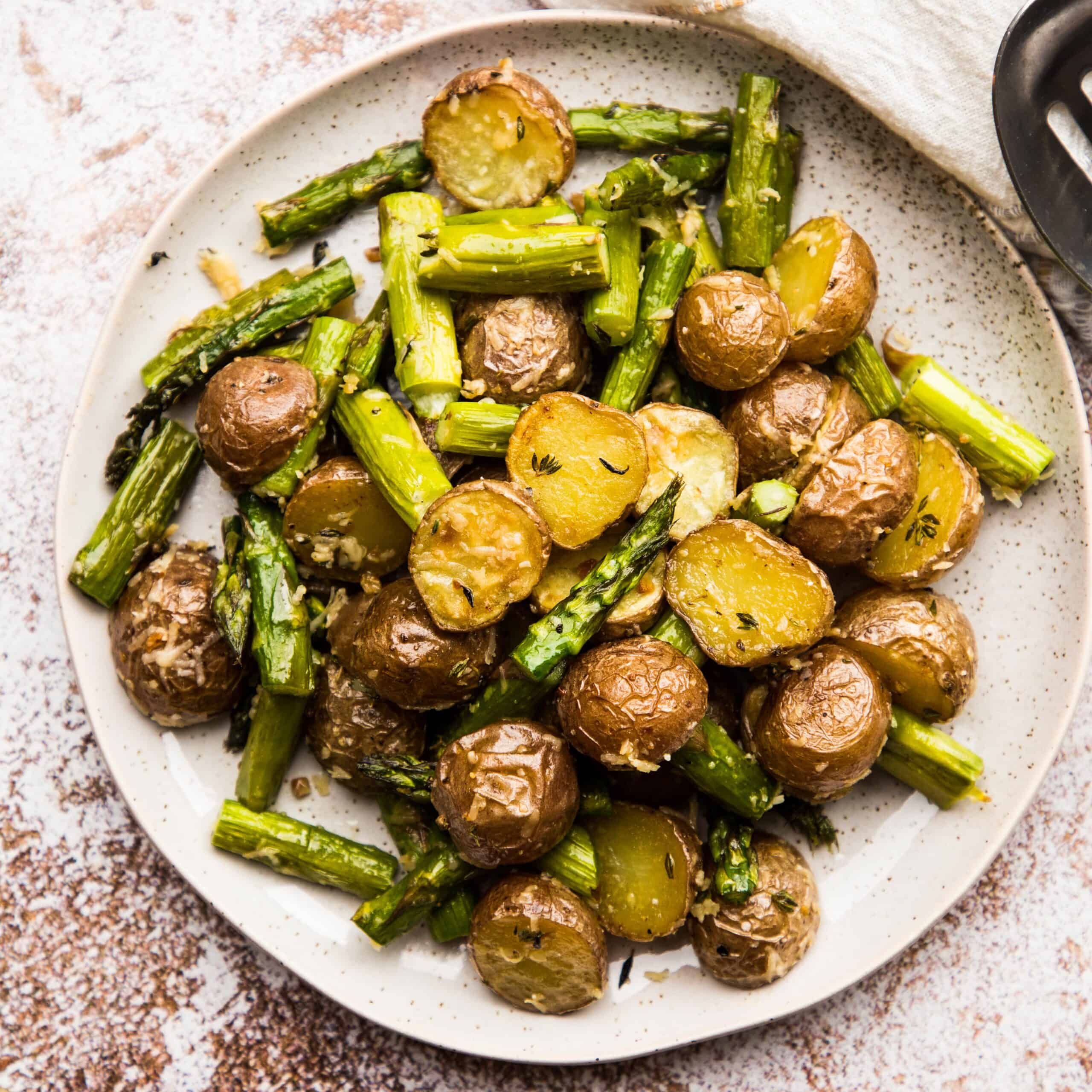 Overhead view of roasted potatoes and asparagus on a plate.