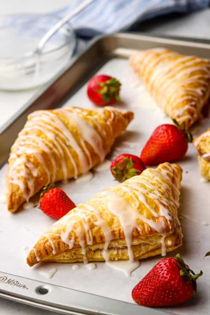 Fresh strawberry turnovers on a baking tray.