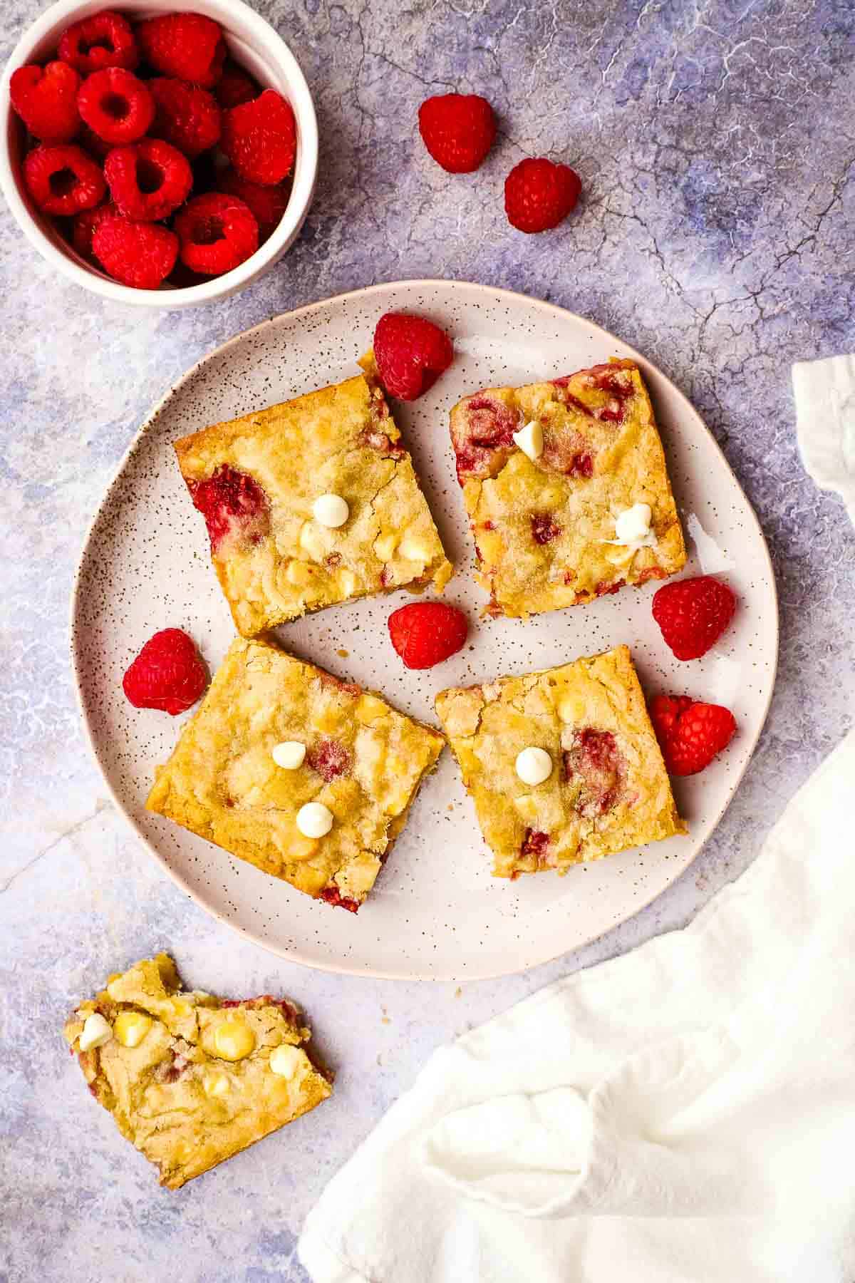 White chocolate and raspberry blondies on a plate.