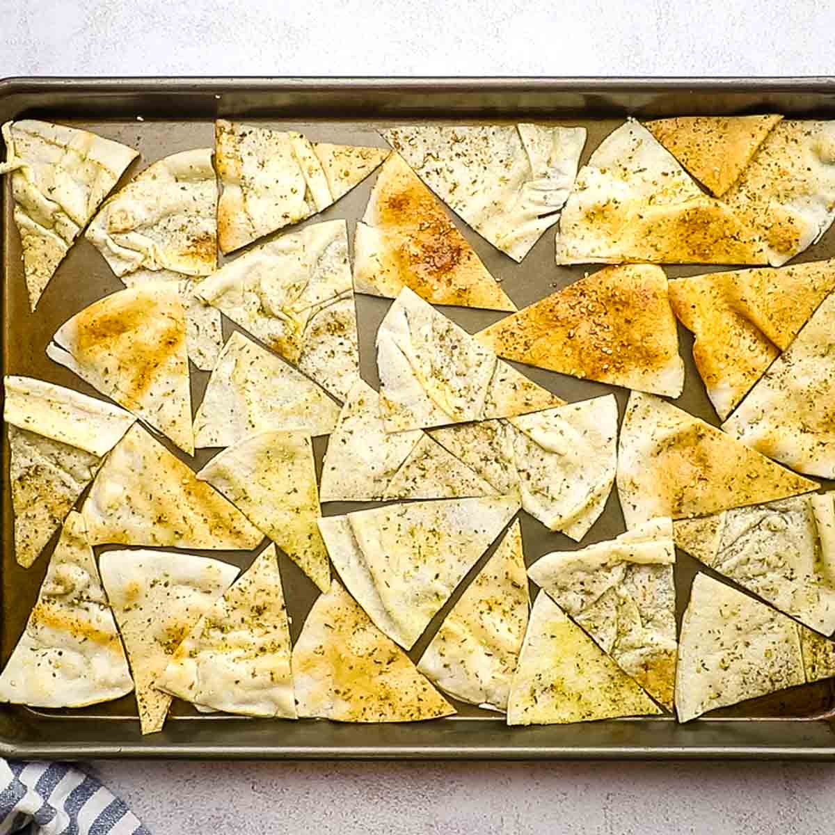 spreading pita chips on a baking sheet