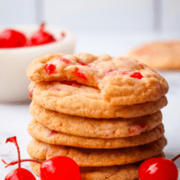 cherry cookies stacked with cherries lying around