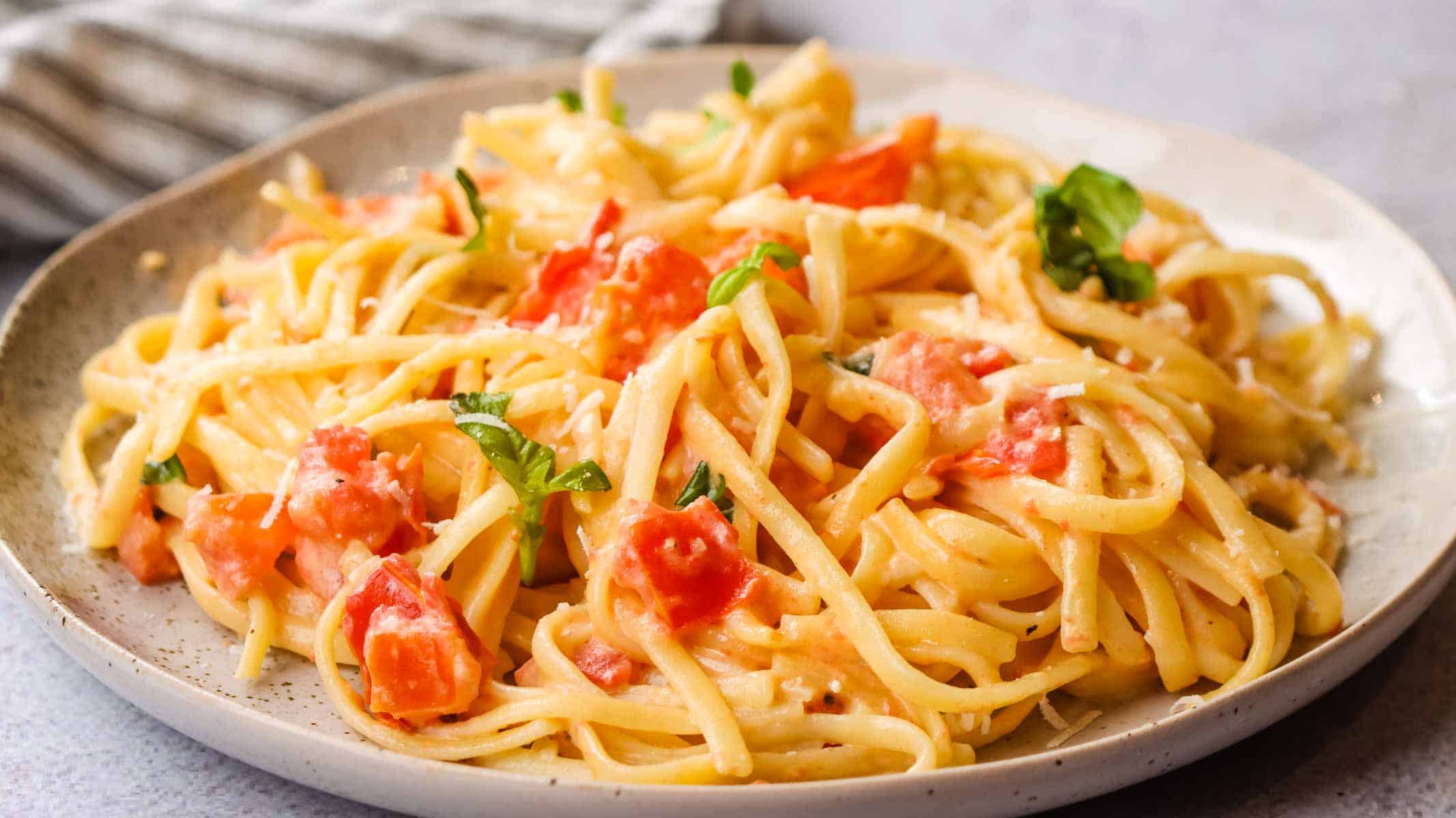 A plate of pasta with tomato alfredo