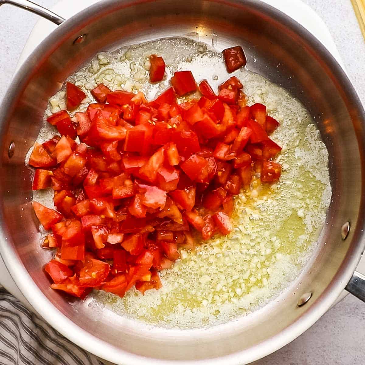 tomatoes added to the butter and garlic in the pot