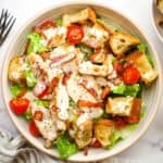 an overhead view of a blt chicken salad on a plate with dressing