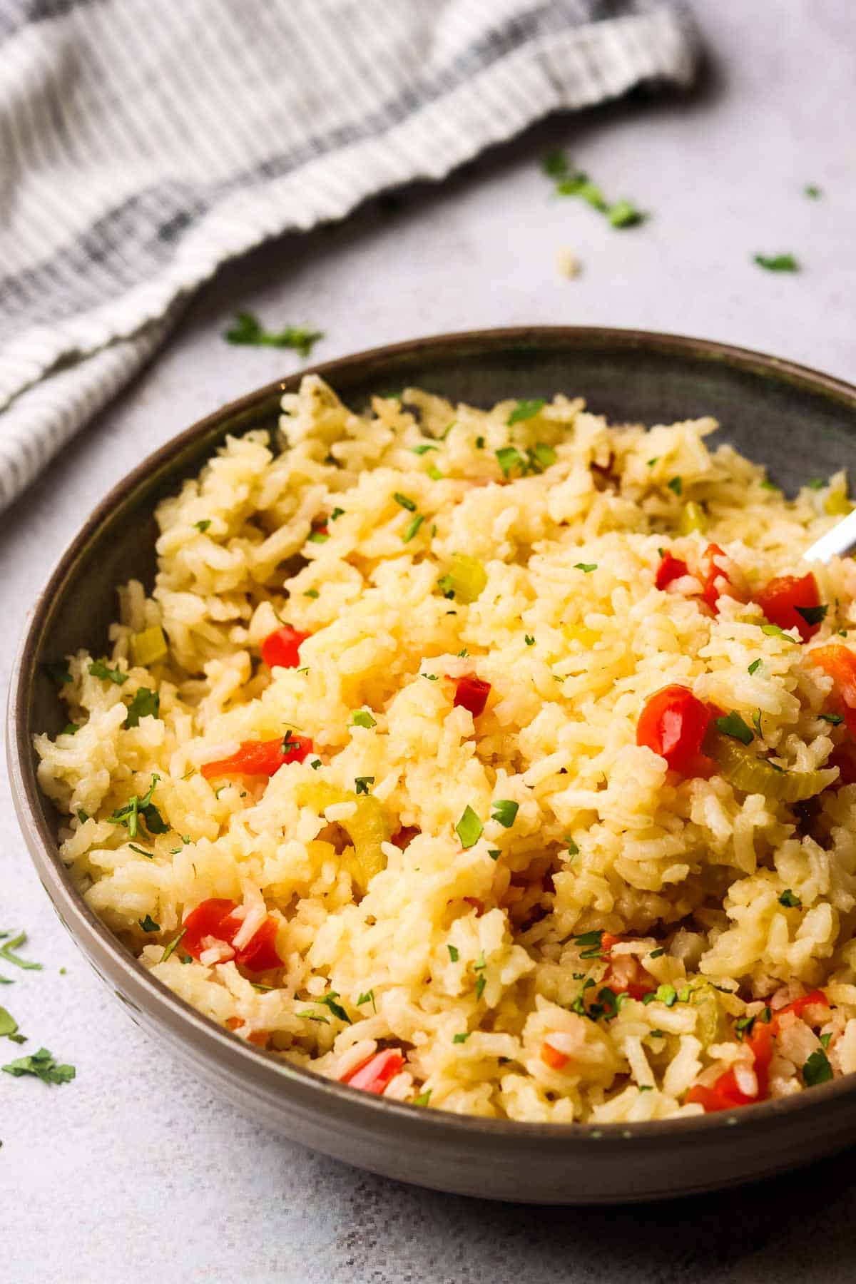 Side view of a bowl of Cajun rice with a napkin in the background.